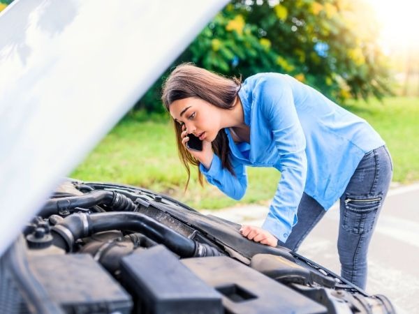 Woman Checking a Broken Down Car